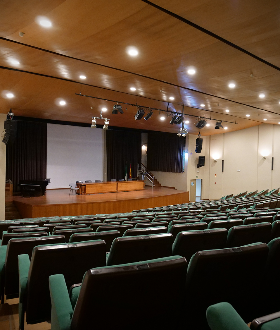 Imagen del escenario elevado del salón de actos de la Facultad de Filosofía y Letras capturada desde el punto de vista del público